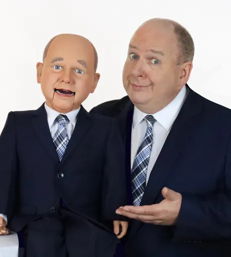 Darren Carr and his look-alike puppet smiling.